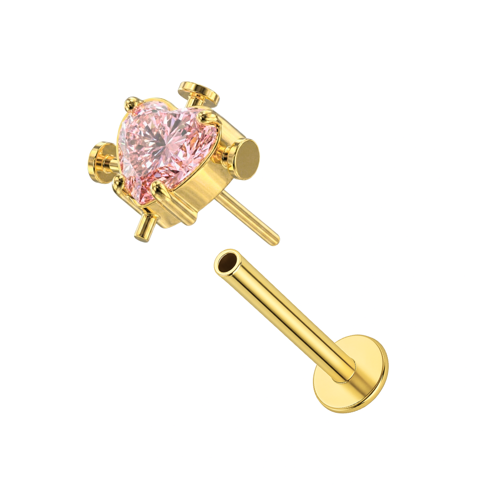 Exploded view of gold G23 titanium threadless labret stud with pink heart CZ, showing push-fit flat back design for secure wear.