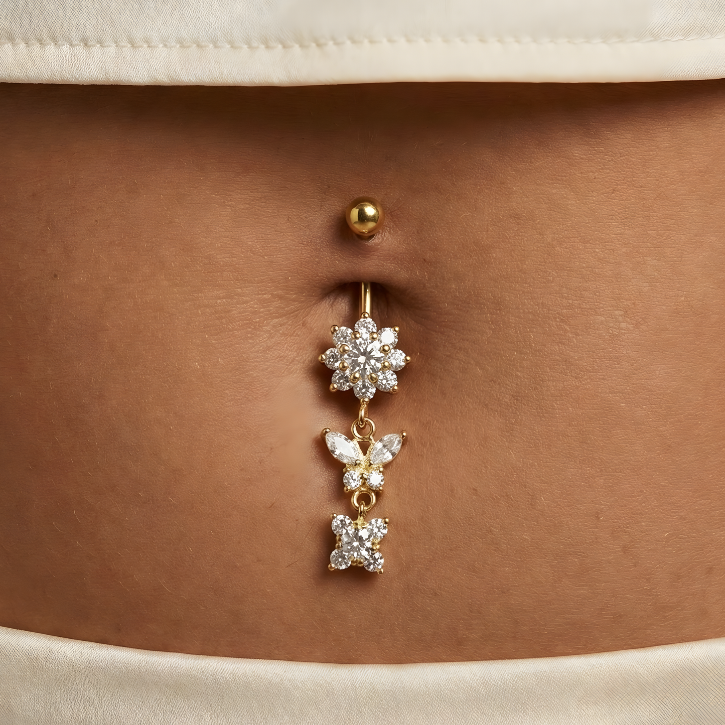 14K Gold Jewelled Trio Dangling Belly Ring worn on navel, showcasing sparkling cubic zirconia accents ideal for special occasions and chic outfits.