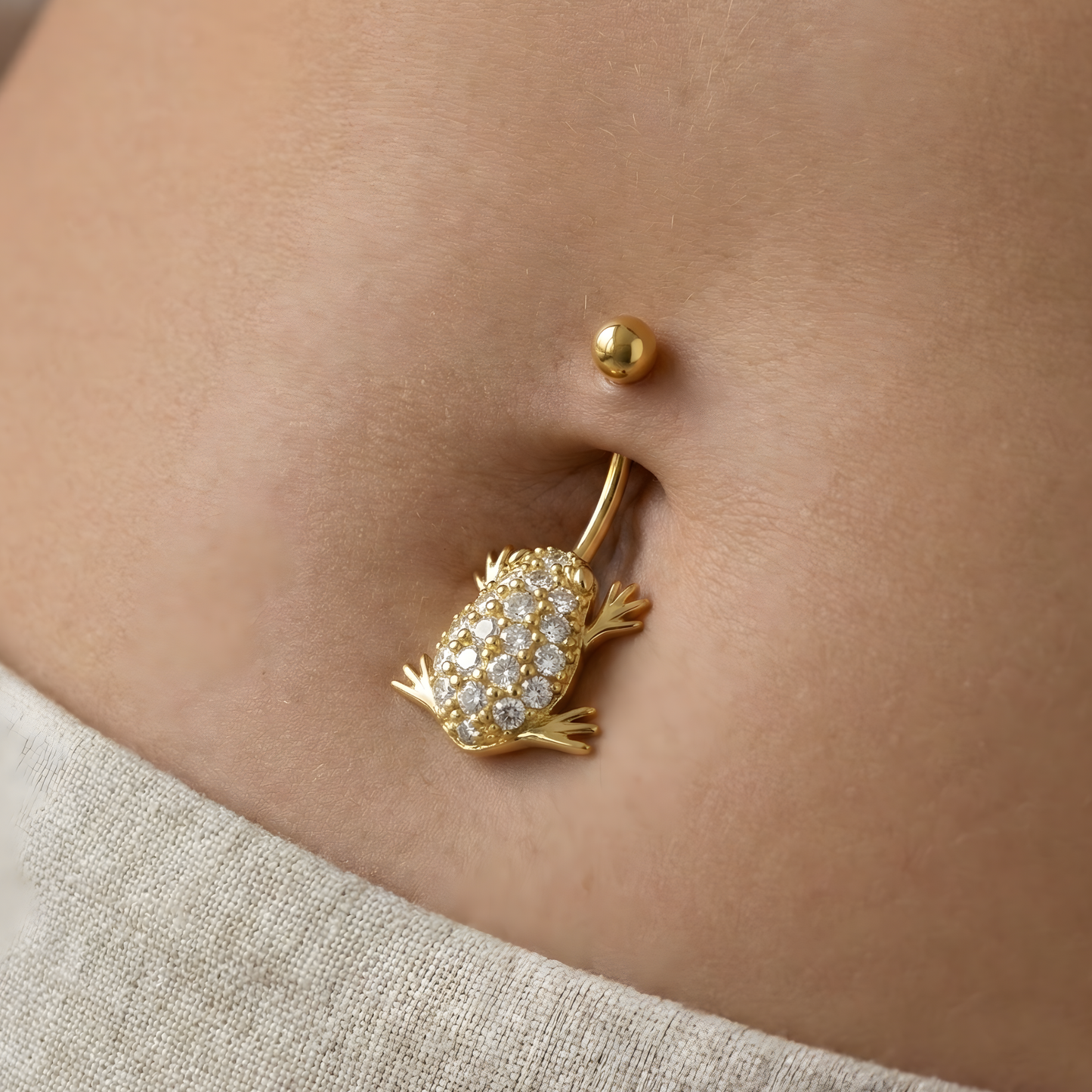 Charming 14ct Gold Jewelled Frog Belly Button Ring worn on a belly, showcasing its playful frog shape and shimmering jewel details in 14K gold.