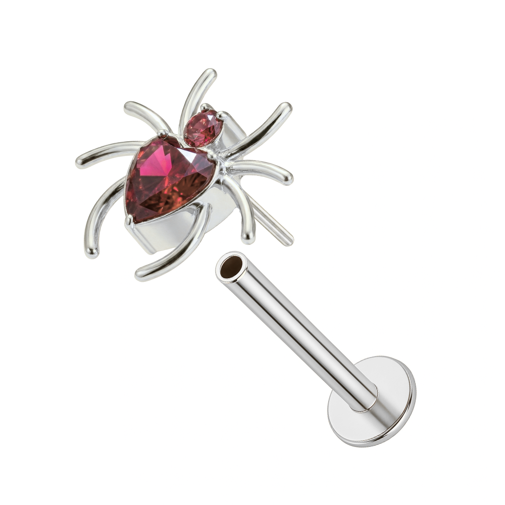 Disassembled silver spider heart threadless stud in G23 titanium with pink CZ stones, highlighting push-fit flat back design for comfort.