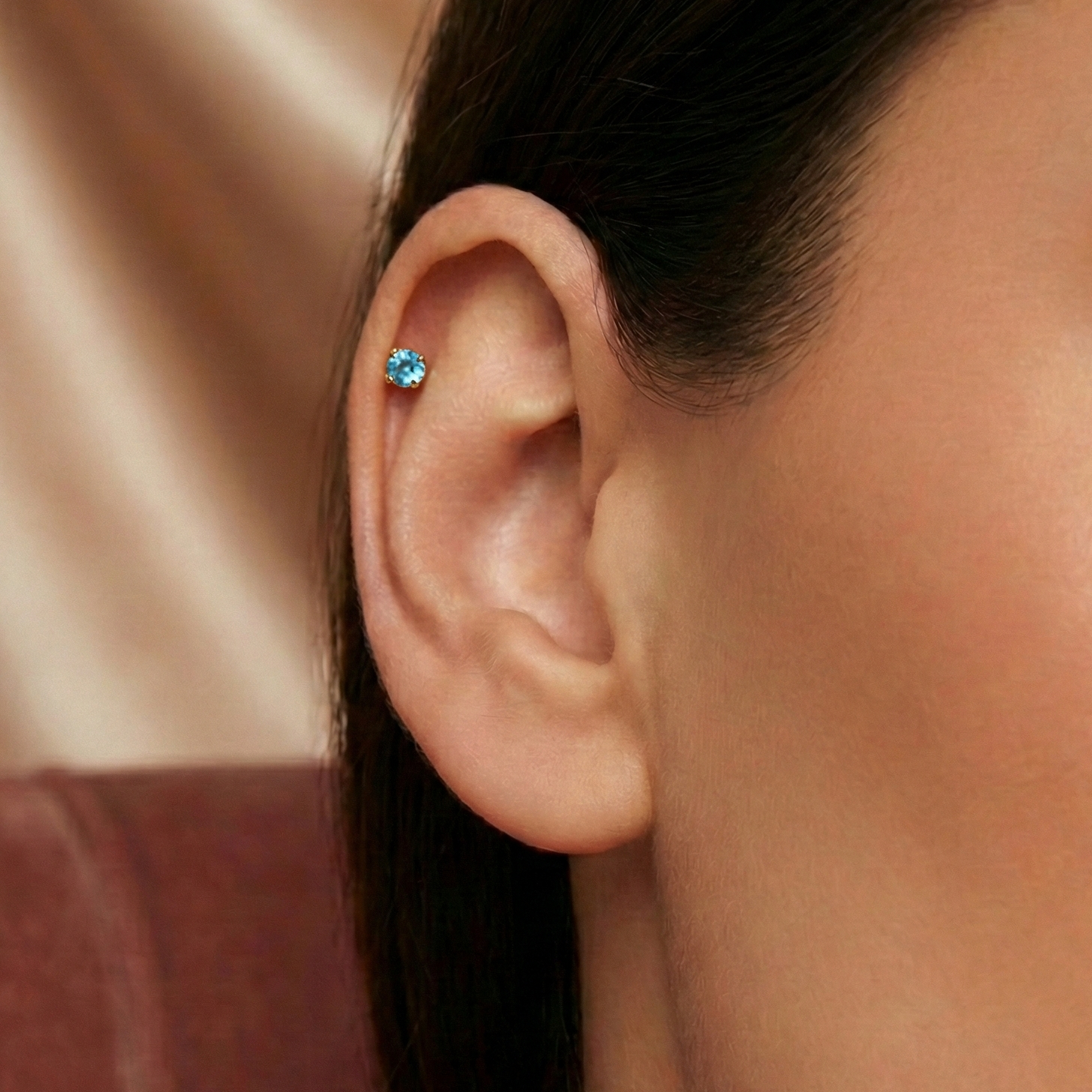 14K Gold Blue Topaz Natural Stone Flatback Stud worn on ear cartilage, showcasing secure internal thread fit and vibrant gemstone sparkle.
