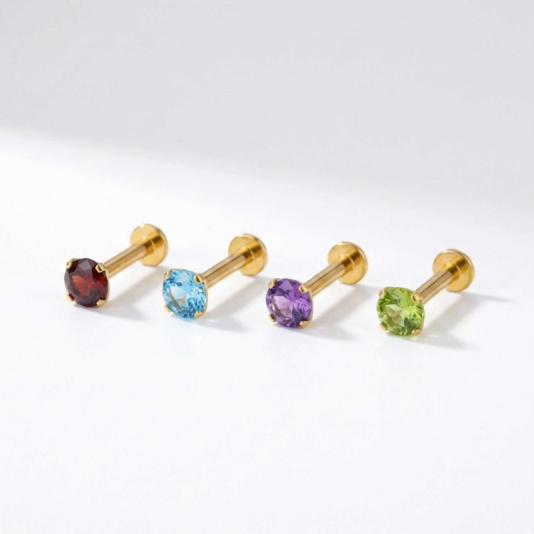 Collection of Minimal 14K Gold Natural Stone Flatback Studs in garnet, blue topaz, amethyst, and peridot, perfect for mix-and-match cartilage or nose piercings.
