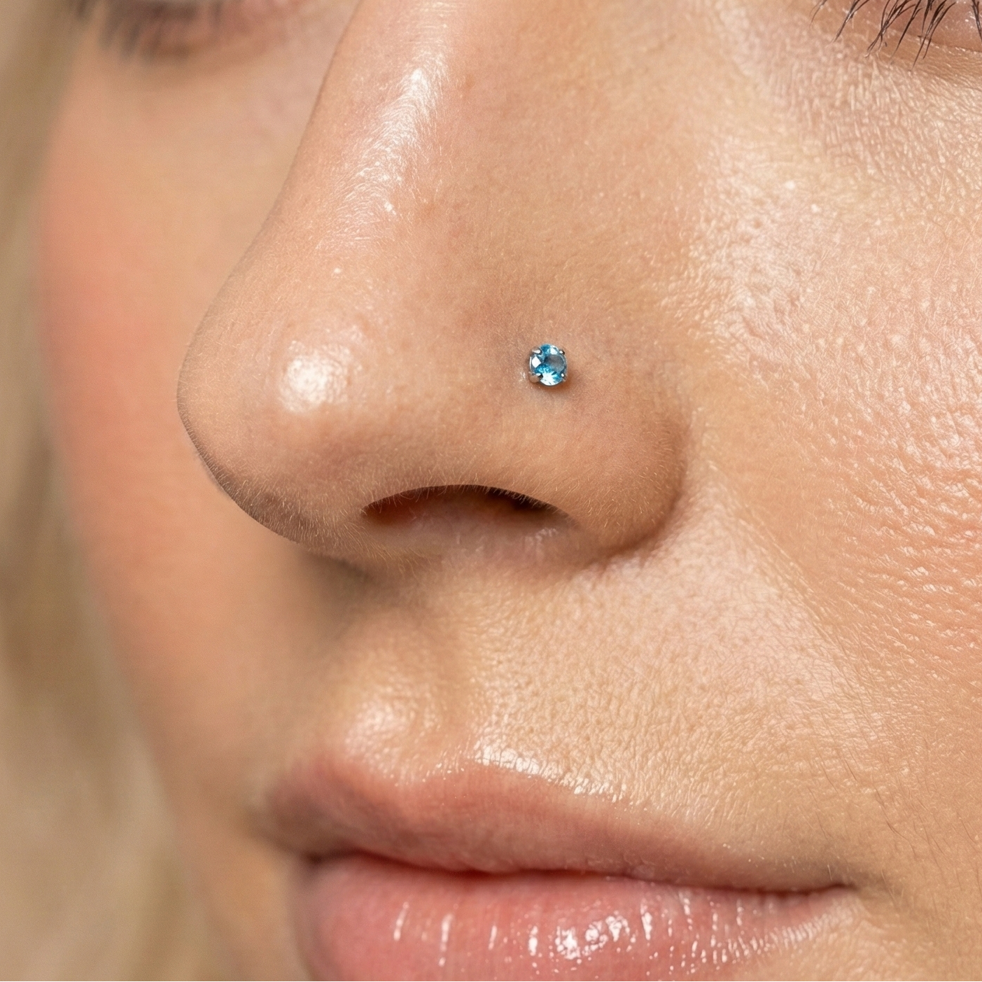 14K Gold Blue Topaz Natural Stone Nose Stud worn on nose, showcasing elegant claw-set gemstone in stylish body jewelry accessory.